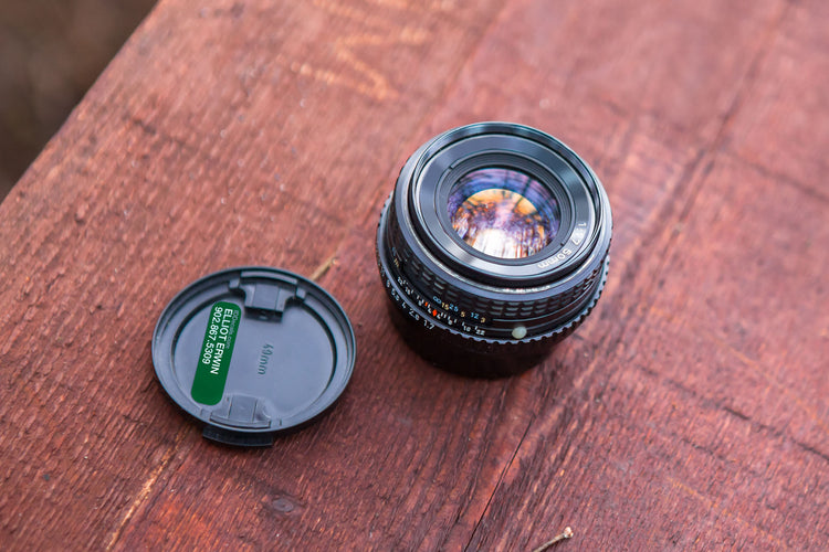 Vinyl identification decal on professional camera lens: Customized label with owner's name and phone number, enhancing professionalism and easy identification of the camera equipment.