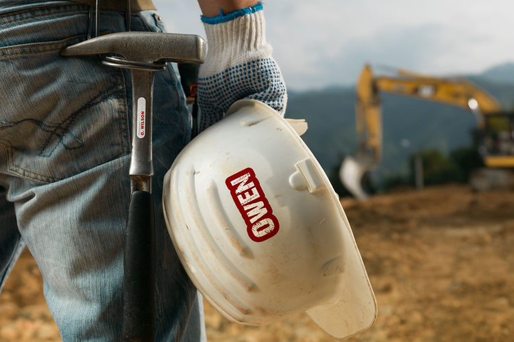 Construction worker with vinyl identification sticker on tools and hardhat: Personalized identification label on tools and hardhat, promoting safety and easy recognition of the worker's equipment on a construction site.